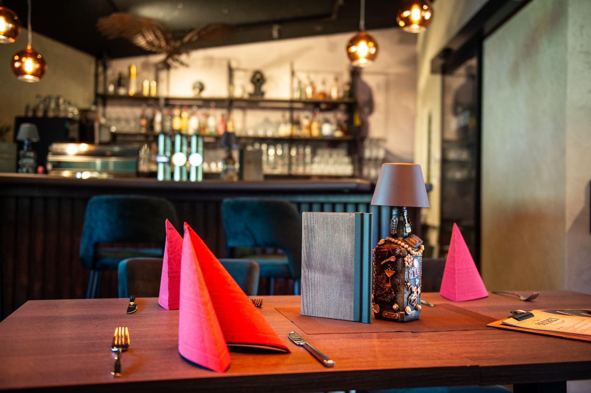 Gedeckter Tisch im The Secret Berwang mit Blick auf die Bar im Hintergrund